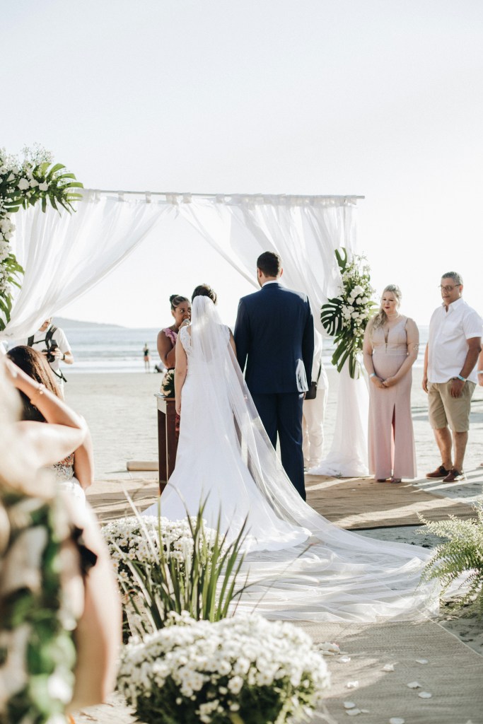 pareja de novios en altar celebrando bodas en la playa
